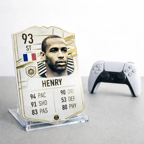 FUT football card display stand holding a Henry card next to a PlayStation controller